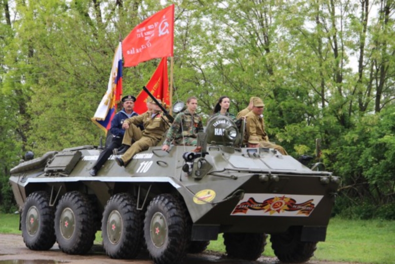 В Нововладимировском поселении ветеранов приехали поздравить на бронетранспортере.